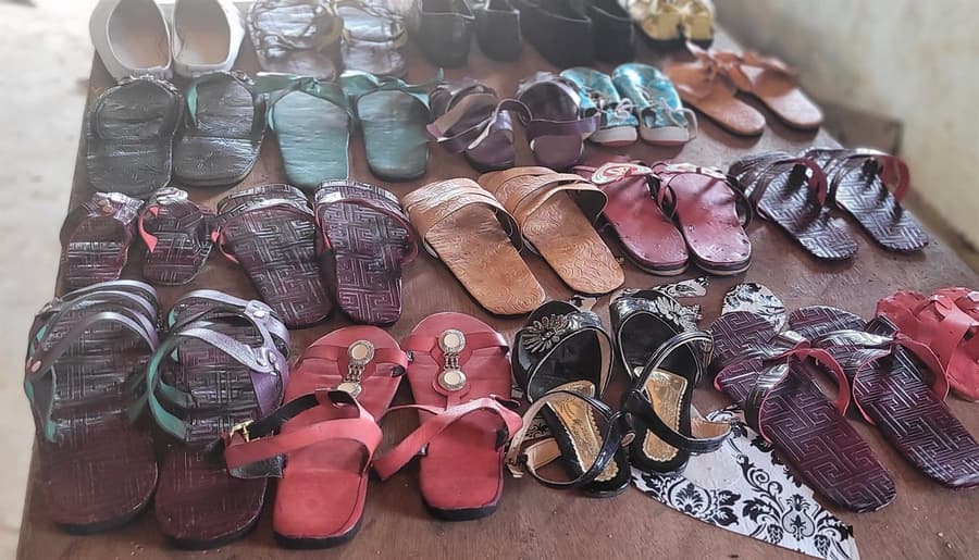 Rows of finished leather sandals laid out on a workbench