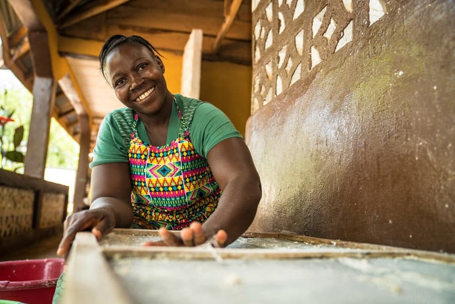 A woman smiling beside a soap-production trough at the skills centre